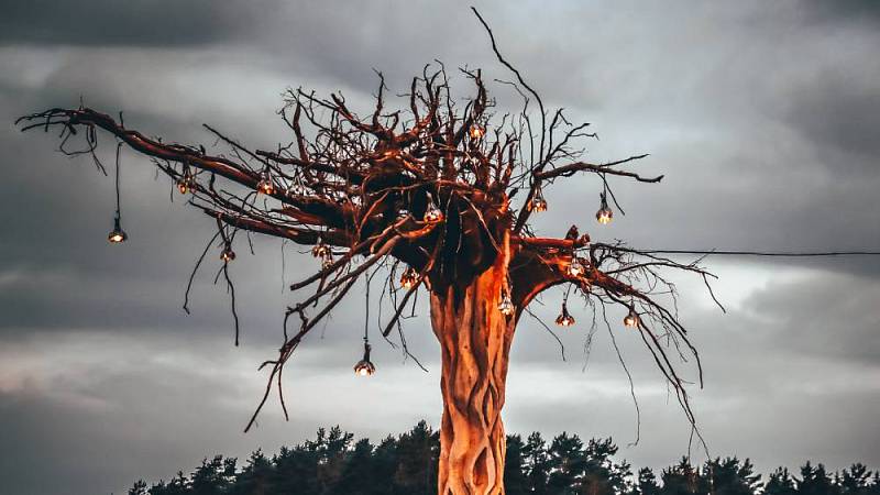 Geschnitzter Baum mit Dekorationselemente auf dem elektronischen Musik-Festival Klangtherapie.