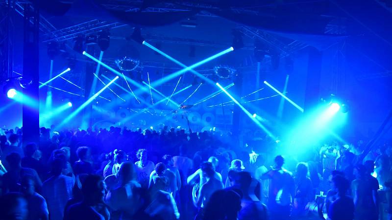 Die Sandpalast-Bühne bei nächtlichem Betrieb. Diskokugeln sowie Licht-Elemente dienen als Deko-Elemente. Viele feiernde Besucher genießen die elektronische Tanzmusik.