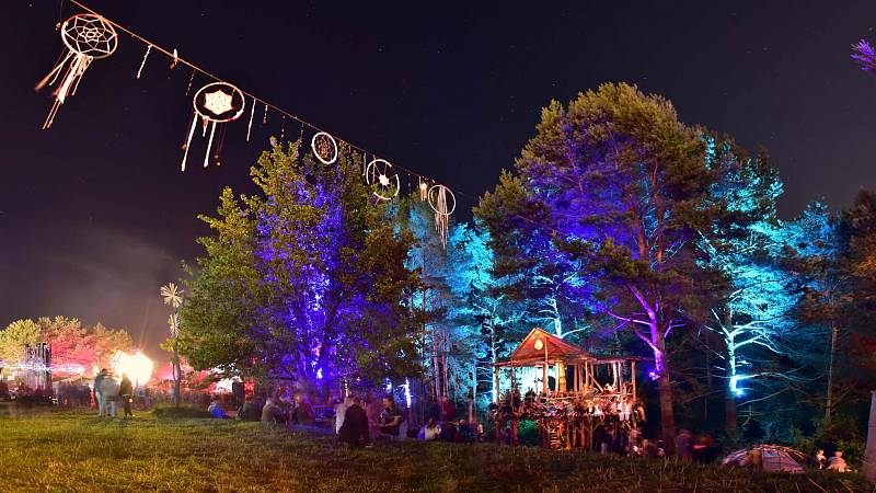 Traumfänger als Deko-Element auf einer Schnur, welche sich über das Festivalgelände zieht und an umliegenden Bäumen befestigt ist. Im Hintergrund sieht man das Baumhaus sowie die Zauberwäldchen-Bühne.