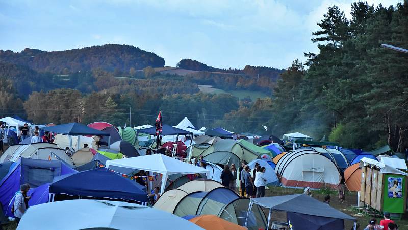 Der gut besuchte Campingplatz vor dem Festivalgelände. Es sind Zelte, Pavillions, Fahnen und die Sanitäreinrichtungen sowie Wasseranschlüsse zu sehen.
