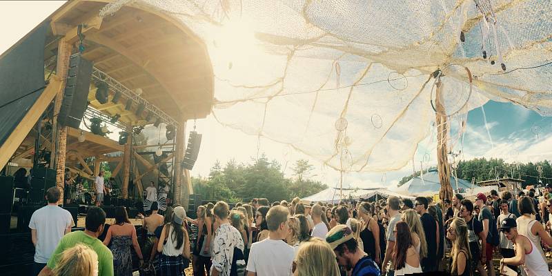 Die Sandpalast-Bühne und ihrer Boho-Dekorationen bei Tag während eines Auftrittes einer Band mit wildfeierndem Publikum