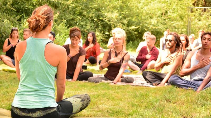 Besucher und Besucherinnen während des Meditierens bei einem Yoga-Workshop in der Natur der fränkischen Schweiz.